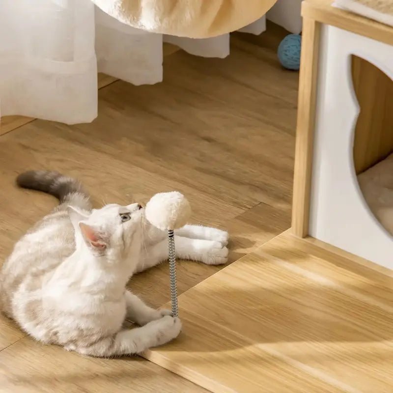 Chaton qui joue avec la balle sur ressort de l'arbre à chat en bois PawNest